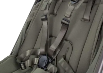 Close-up of olive-green backpack shoulder straps with a central buckle and harness system for a secure fit