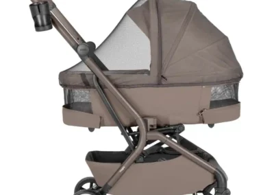 Taupe baby stroller with a bassinet and canopy, four wheels, and an adjustable handlebar.